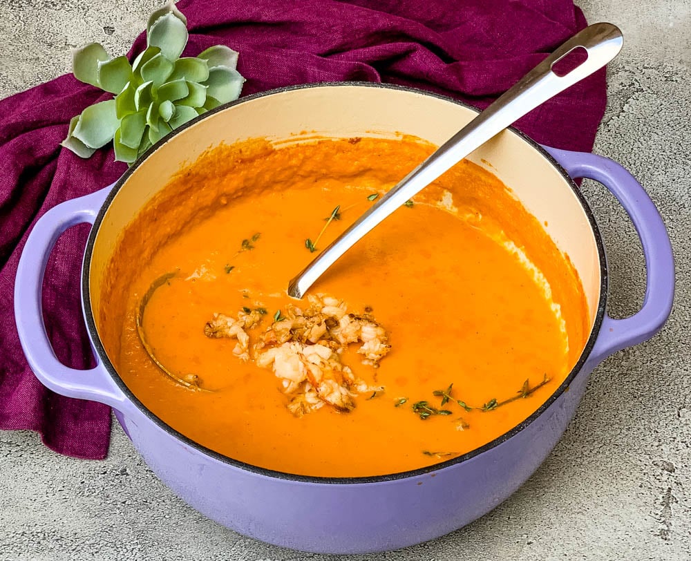 creamy homemade lobster bisque recipe in a purple Dutch oven