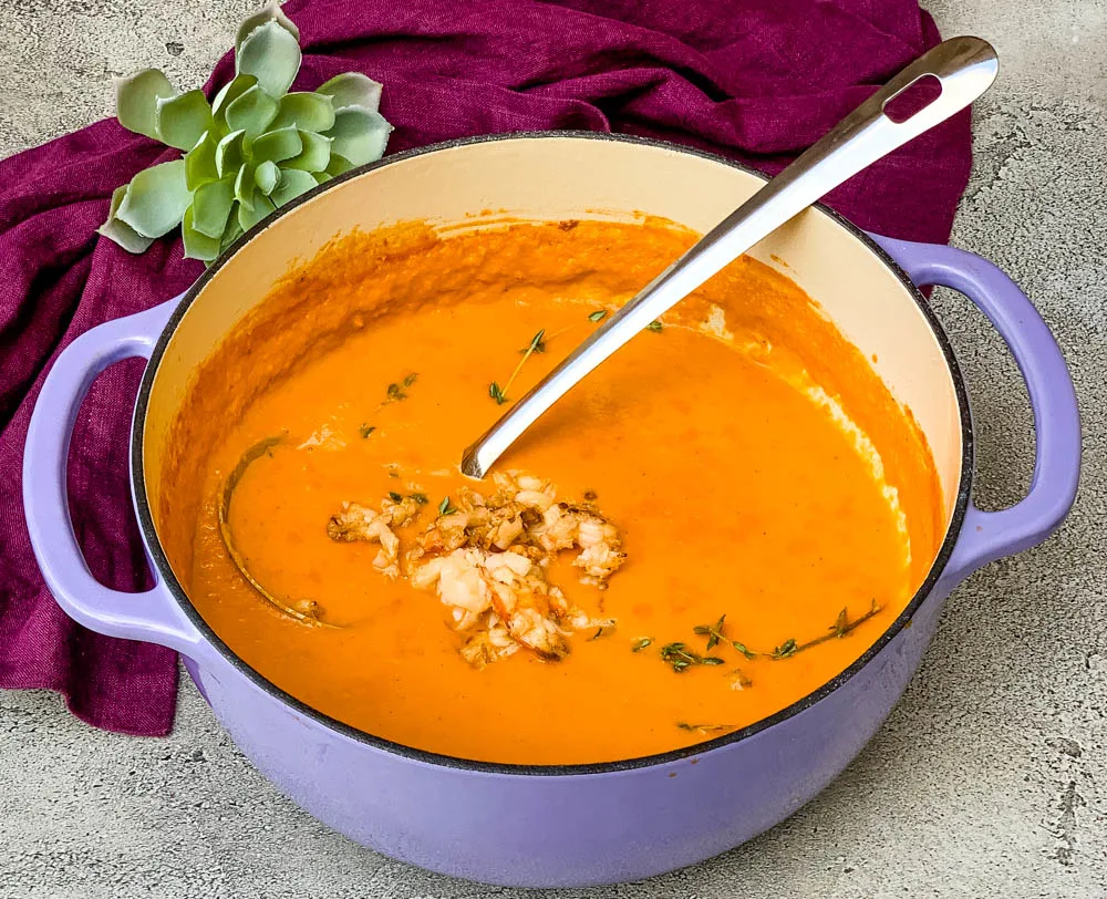 creamy homemade lobster bisque recipe in a purple Dutch oven