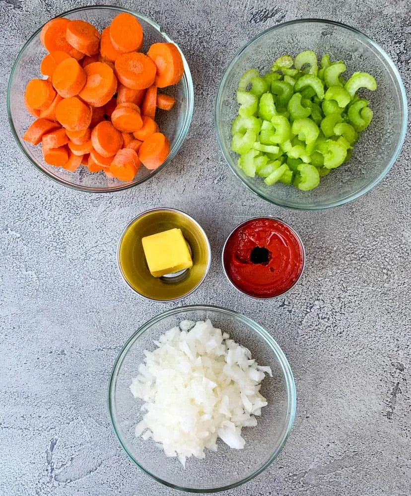 chopped carrots, celery, onions, and butter, and tomato paste in separate bowls