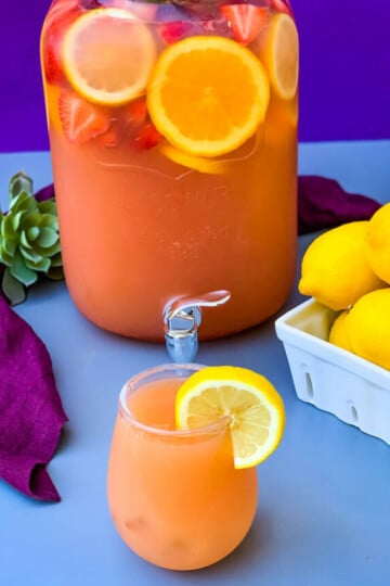 jungle juice cocktail recipe in a 2 gallon glass container with fresh fruit