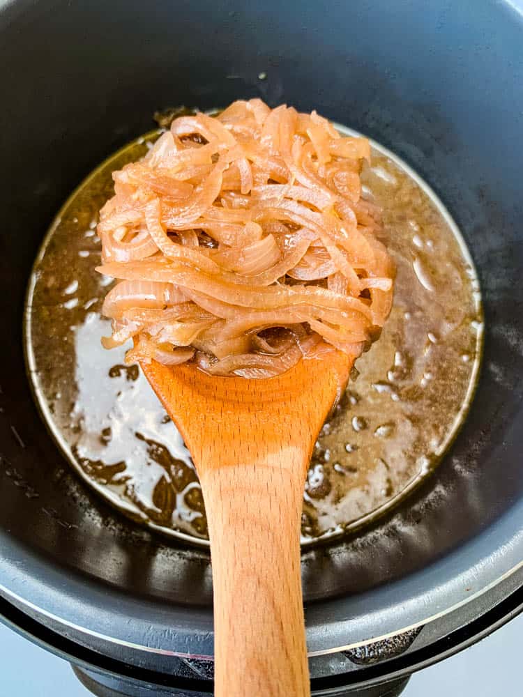 Instant Pot French Onion Soup with a wooden spoon