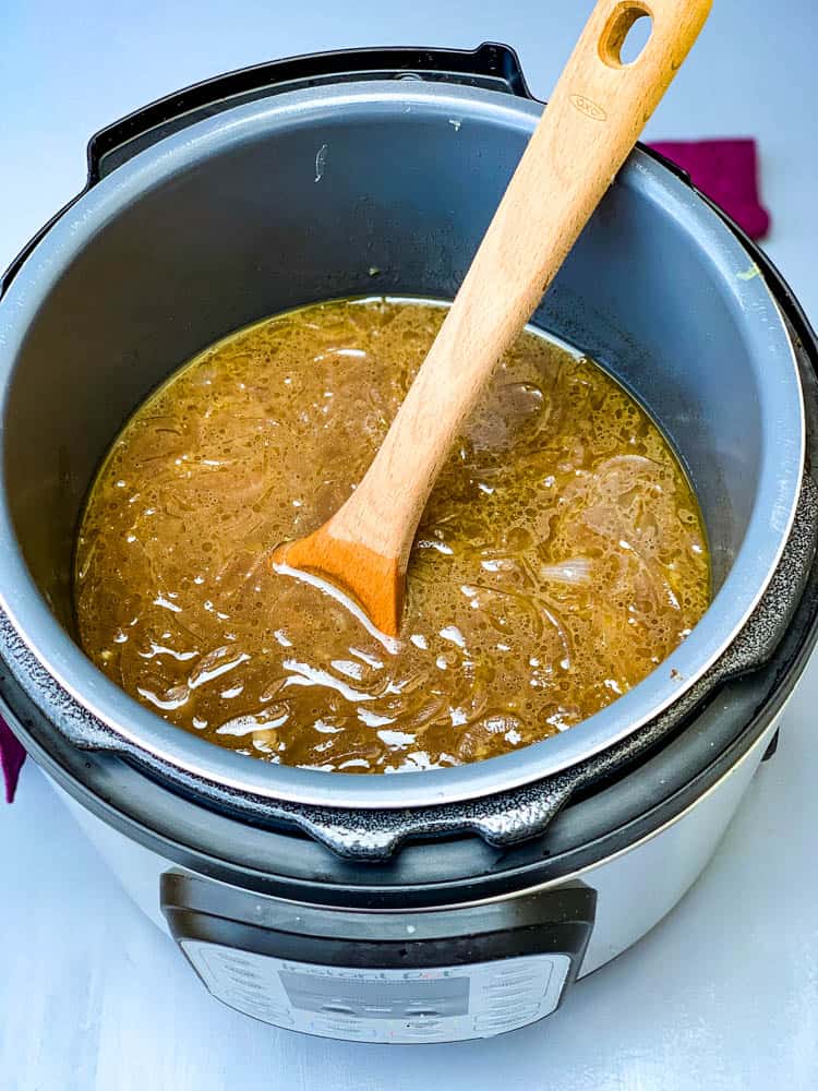 Instant Pot French Onion Soup with a wooden spoon