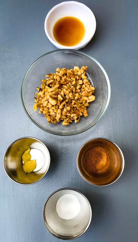 nuts, ginger, and spices in separate bowls for keto zucchini bread