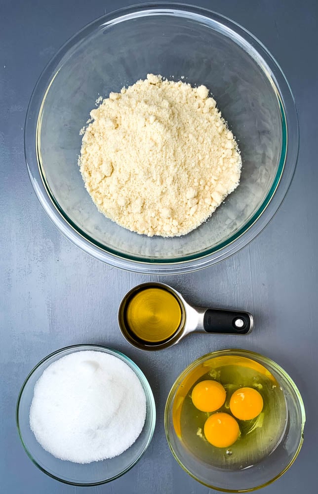 almond flour, sweetener, eggs, and olive oil in separate bowls for keto zucchini bread