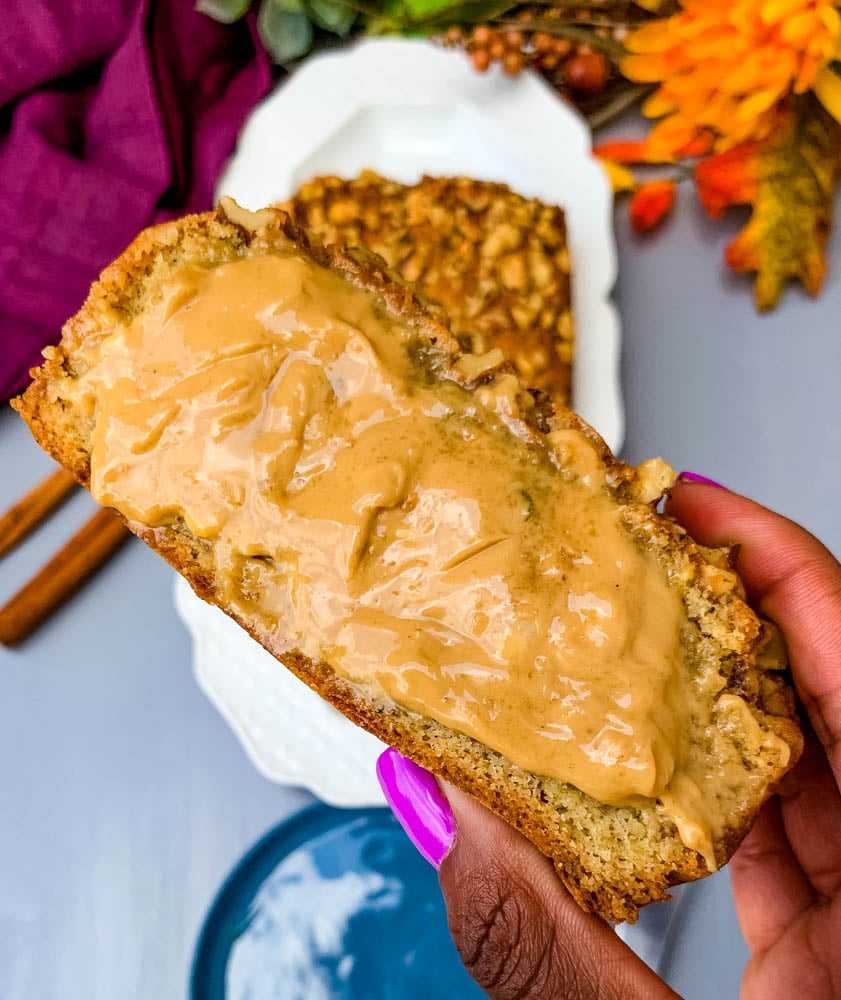 person holding a slice of keto zucchini bread with almond butter