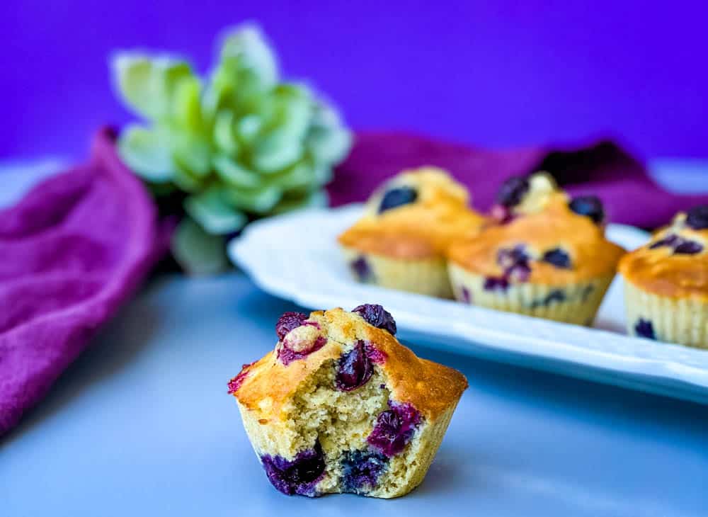 close up shot of an air fryer blueberry muffin with a bite taken out