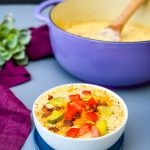 keto low carb cheeseburger soup in a white bowl with pickles, tomatoes, and bacon