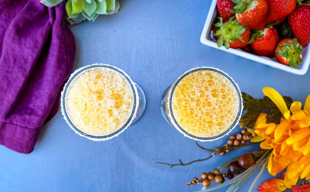 peach bellinis in a glass with strawberries