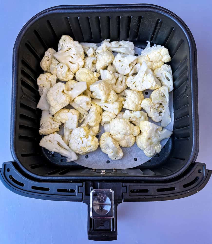 raw cauliflower in an air fryer basket