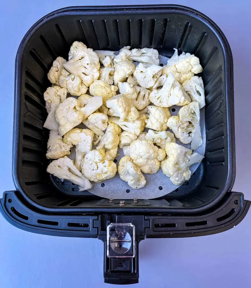 raw cauliflower in an air fryer basket
