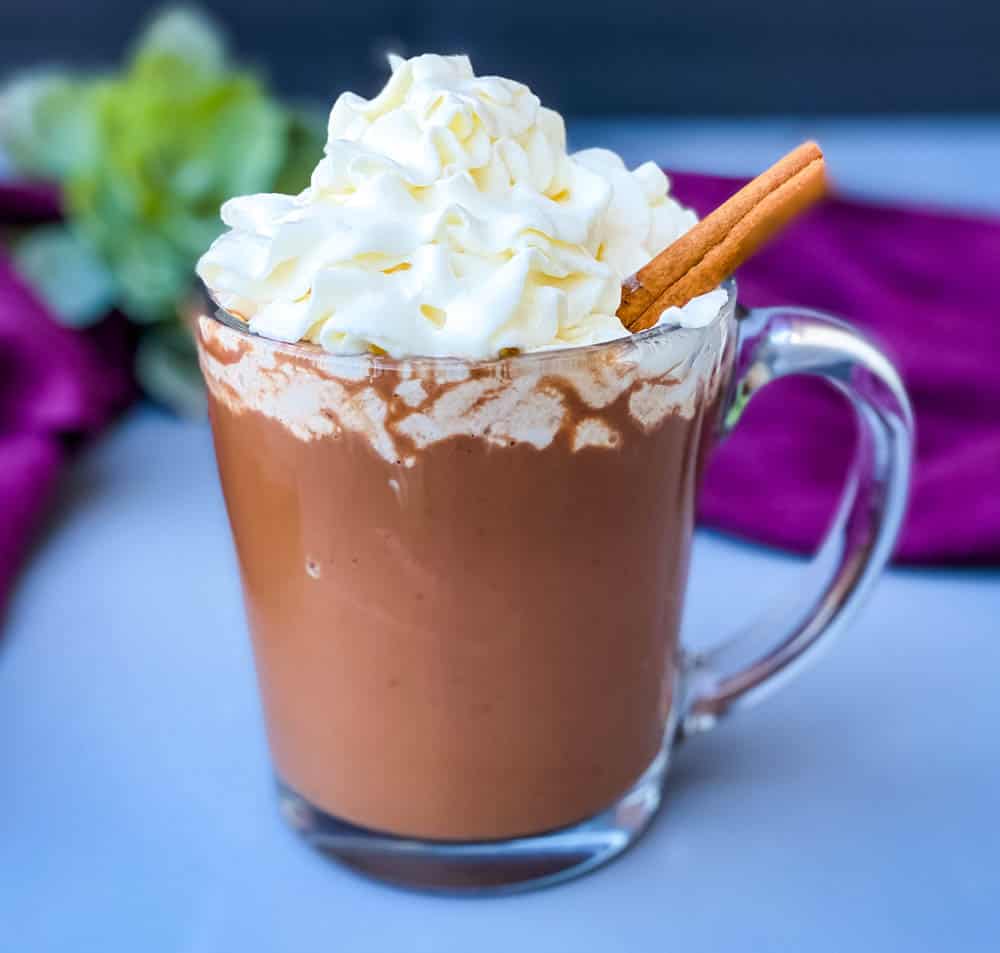 keto low carb hot chocolate in a glass mug with whipped cream and cinnamon