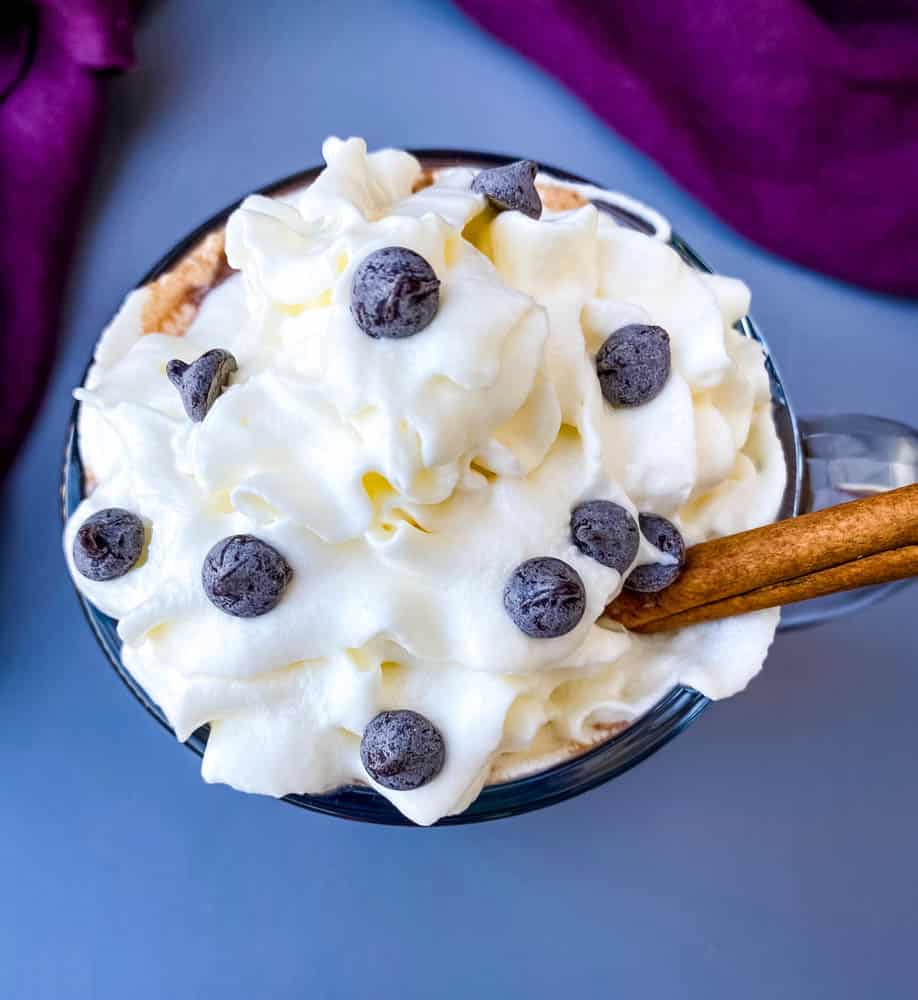 keto low carb hot chocolate in a glass mug with whipped cream and cinnamon and chocolate chips