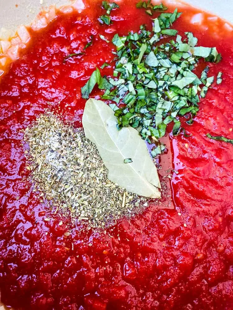 crushed tomatoes and spices in a Dutch oven for keto low carb marinara sauce