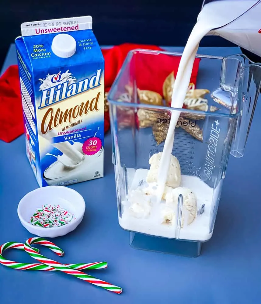 almond milk poured into a blender for peppermint milkshakes