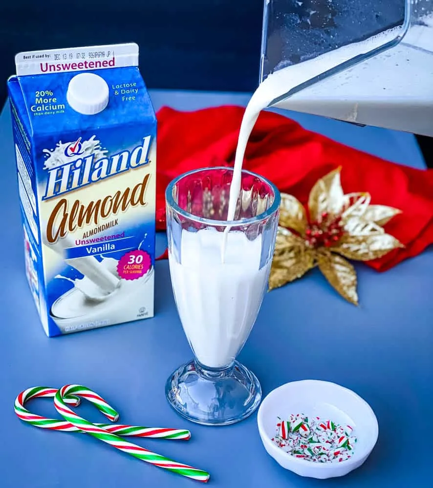 peppermint milkshake being poured from a blender into a glass