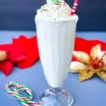 peppermint milkshake with candy canes and whipped cream in a glass with a straw