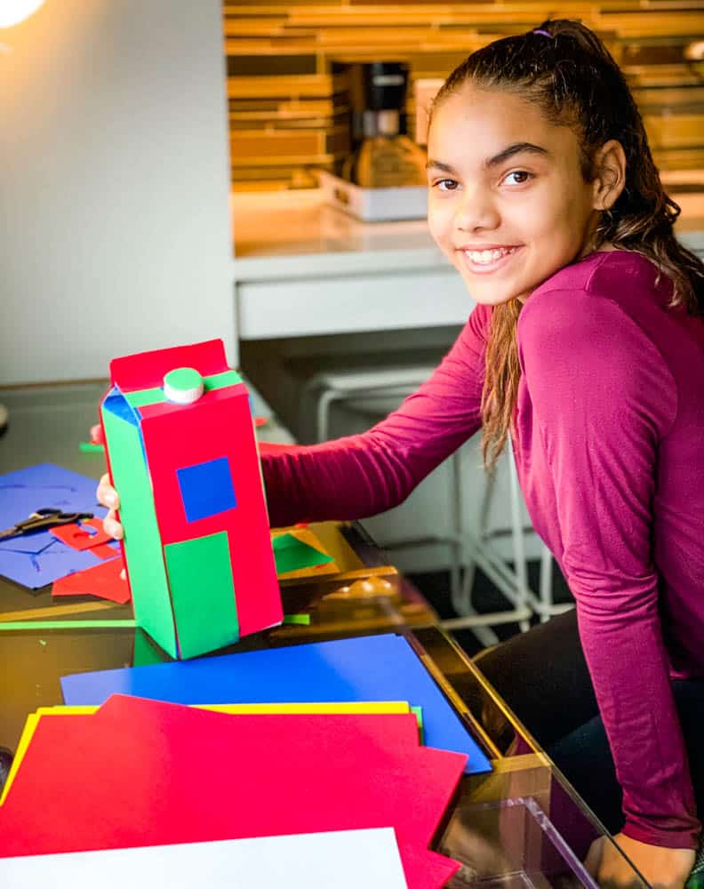 child making Christmas decoration using recycled milk carton