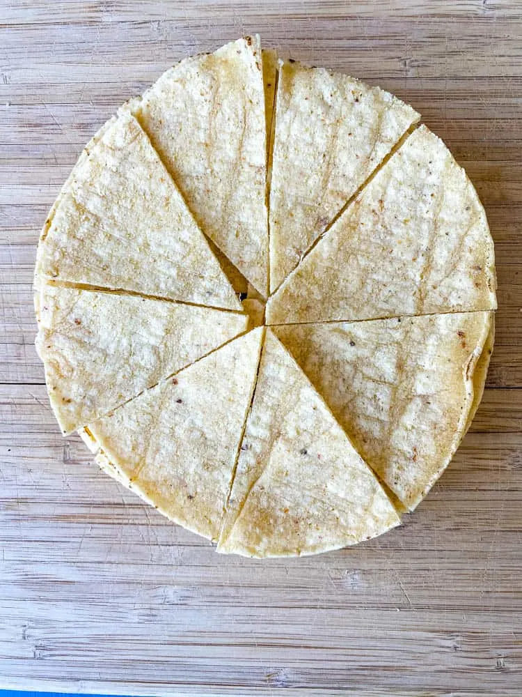 sliced corn tortillas on a cutting board for air fryer tortilla chips