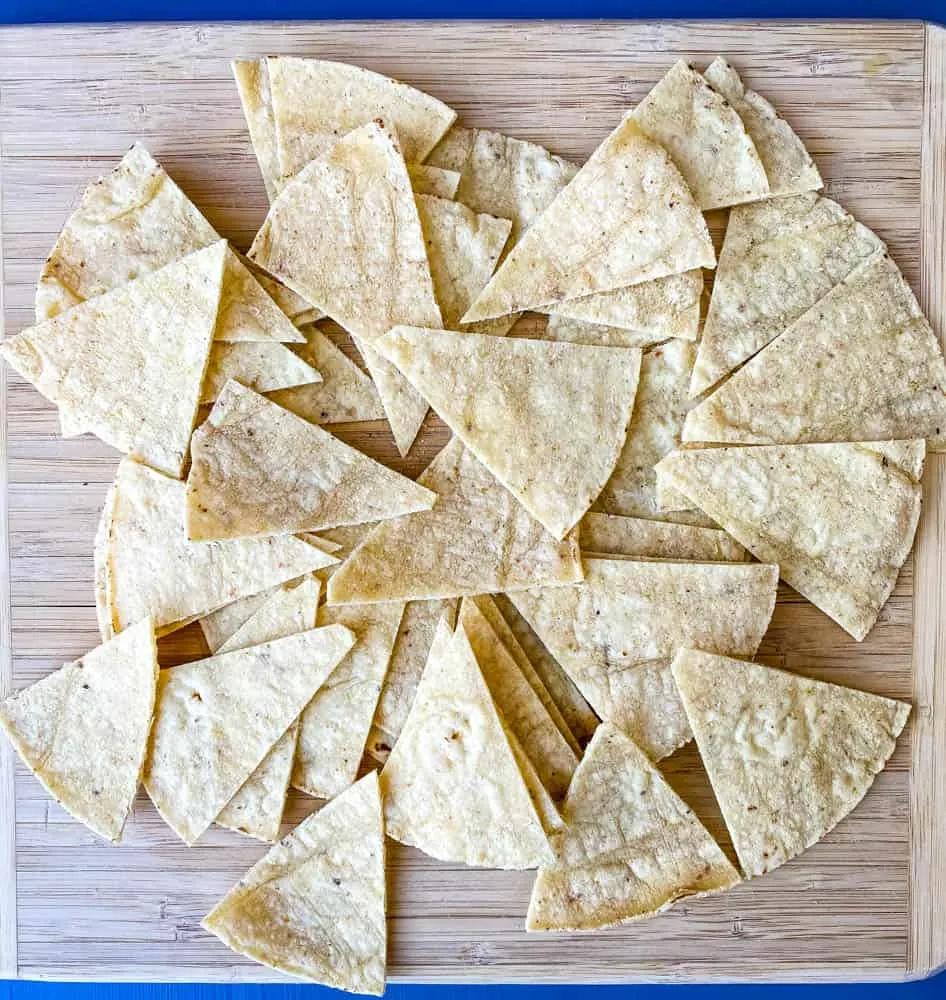 sliced corn tortillas on a cutting board for air fryer tortilla chips