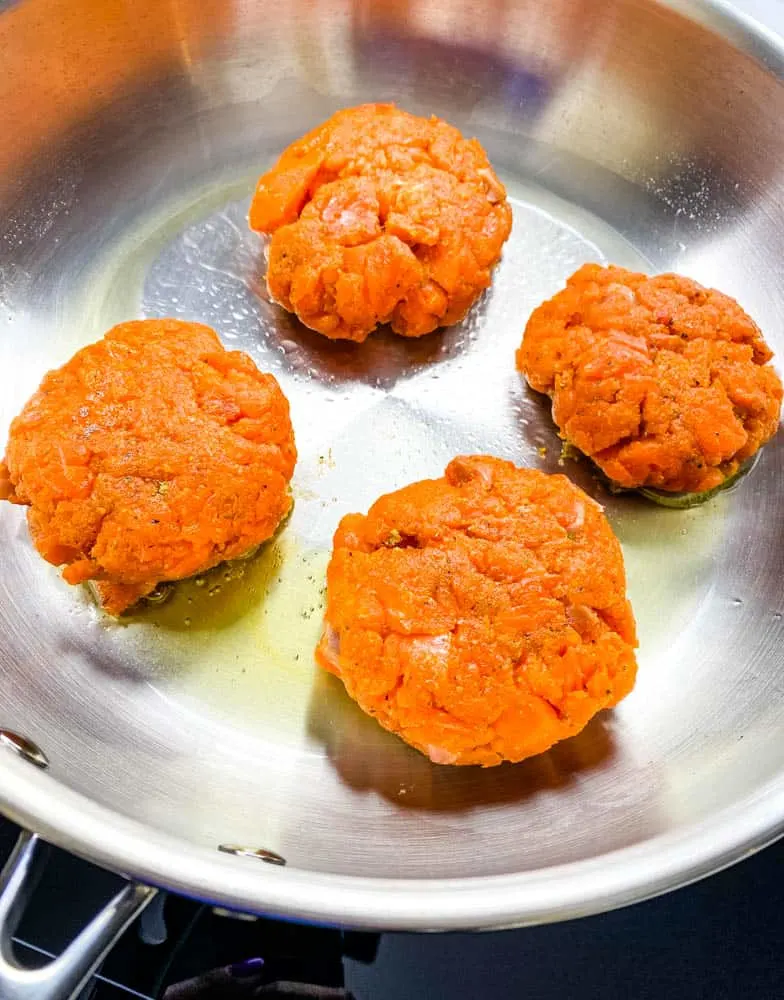 keto low carb salmon patties in a stainless steel frying pan