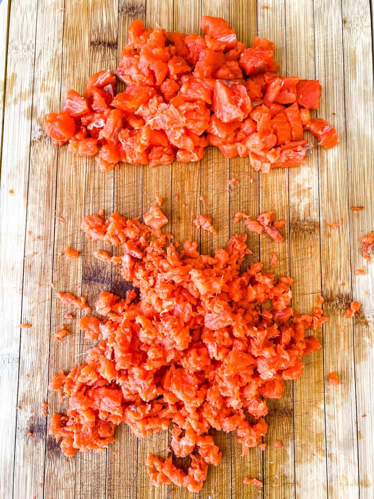 diced and minced salmon on a cutting board