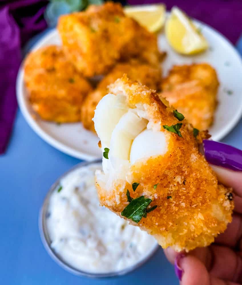 person holding half eaten air fryer fish stick