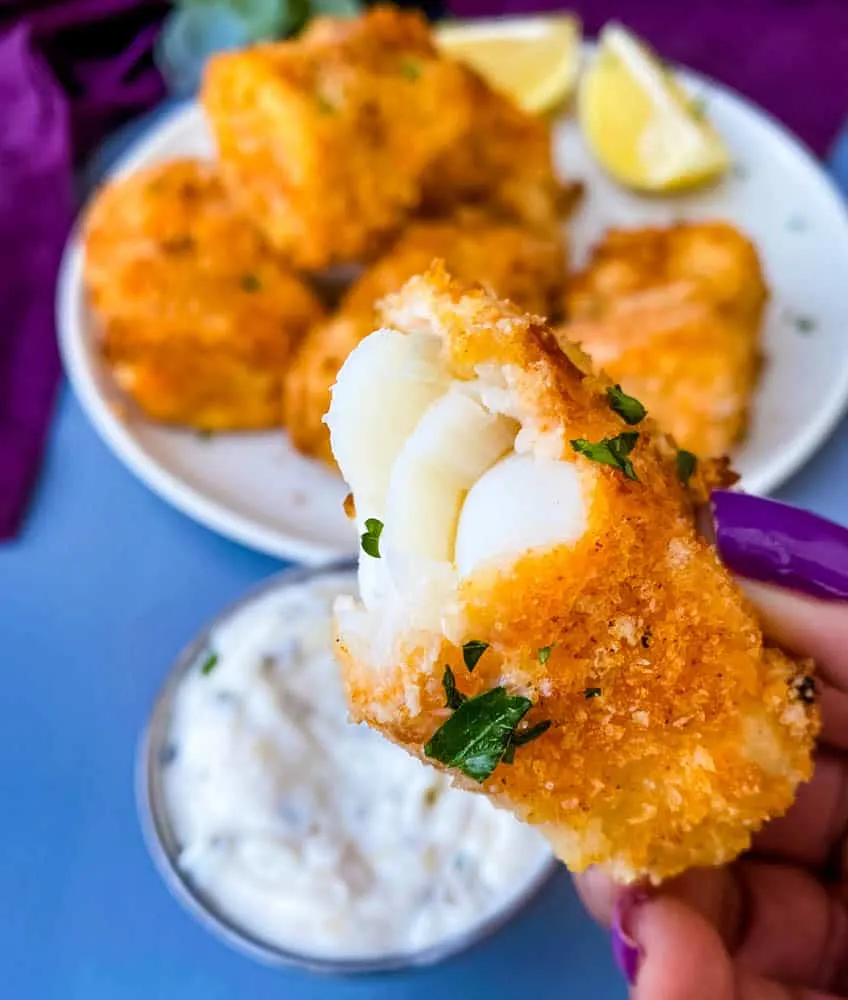 person holding half eaten air fryer fish stick