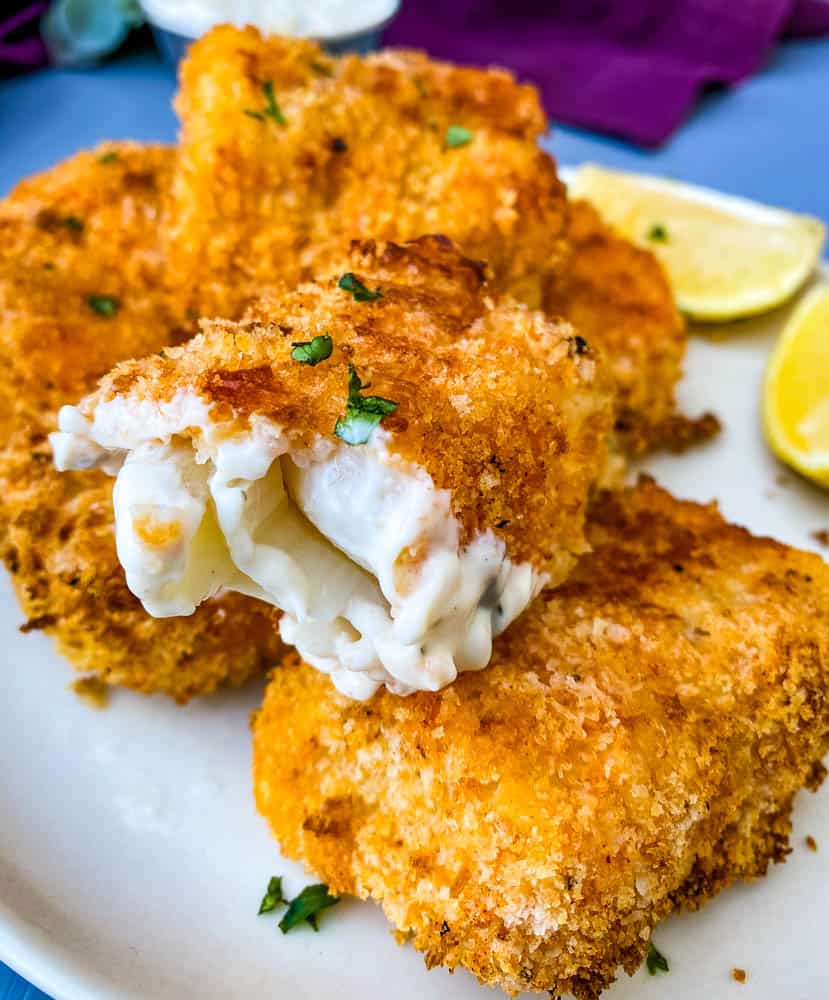 air fryer fish sticks on a plate with one fish stick half eaten