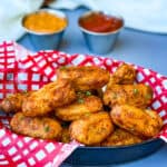 air fryer tater tots in a red and white basket with ketchup and chipotle mayo