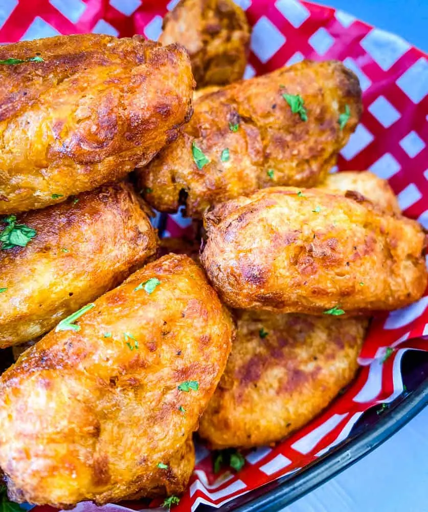 air fryer tater tots in a red and white basket with ketchup and chipotle mayo