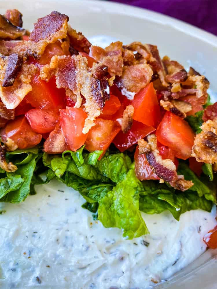 BLT dip with lettuce, bacon, and tomatoes in a serving dish