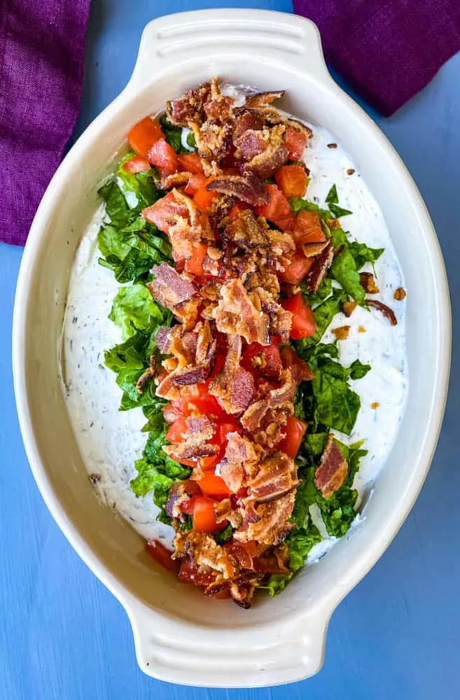 BLT dip with lettuce, bacon, and tomatoes in a serving dish