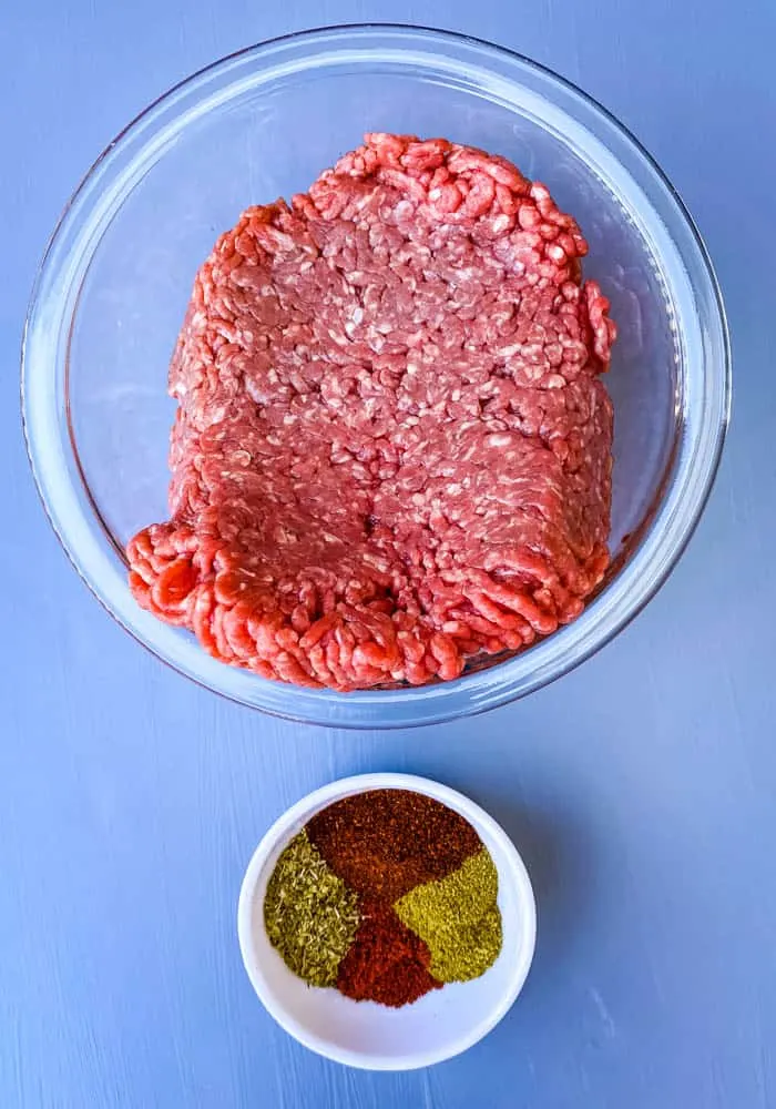 ground beef and chili seasoning in separate glass bowls