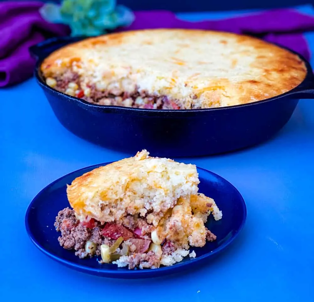 slice of tamale pie and tamale pie in a cast iron skillet
