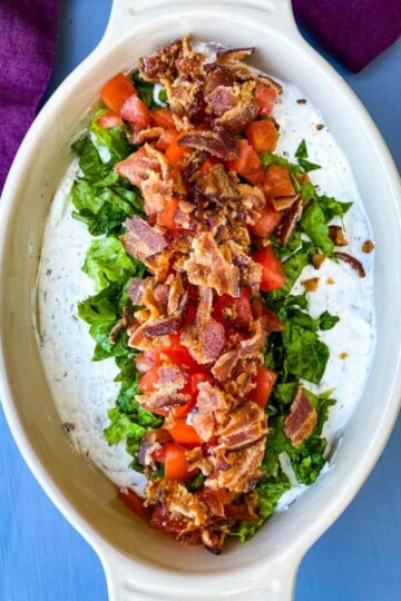 BLT dip with lettuce, bacon, and tomatoes in a serving dish
