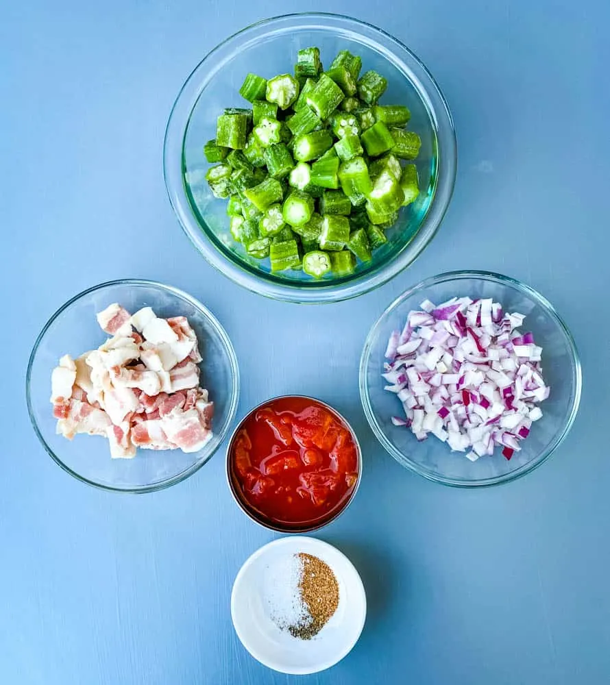 chopped bacon, frozen okra, chopped onions, diced tomatoes, and seasoning all in separate bowls