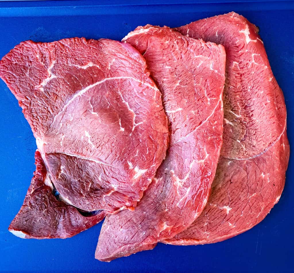 raw sirloin tip steak on a cutting board