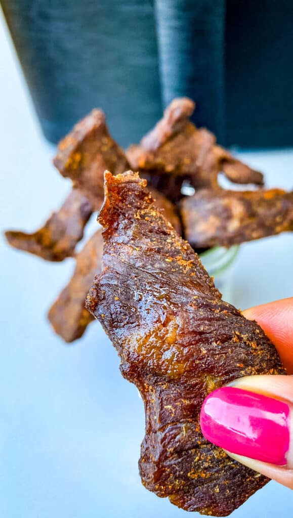 person holding air fryer beef jerky