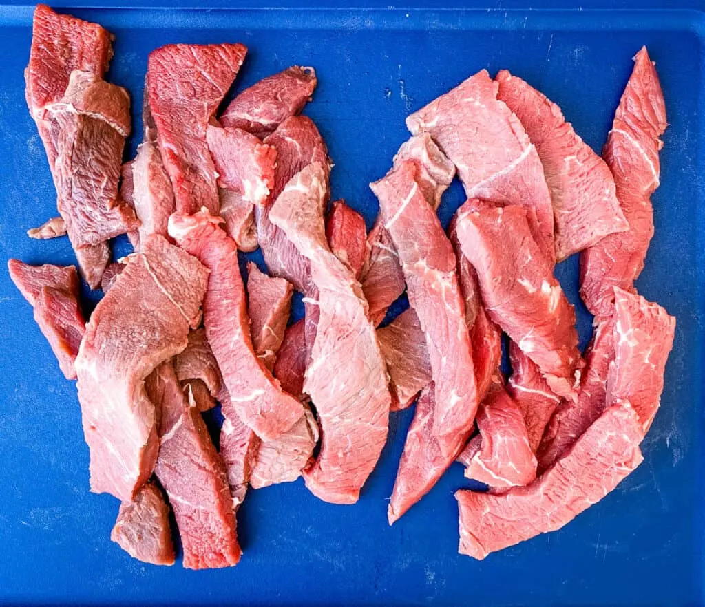 raw slices of sirloin tip steak on a cutting board