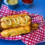 air fryer corn dogs in a basket with a red and white napkin