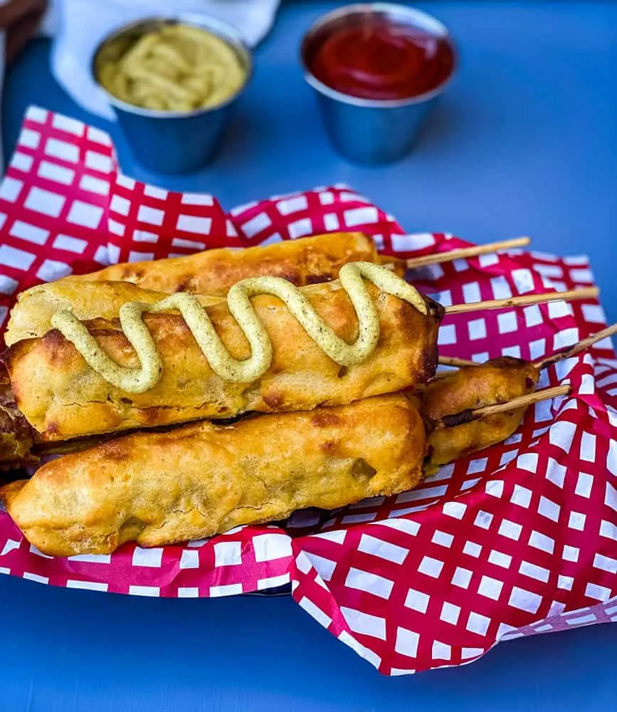 air fryer corn dogs in a basket with a red and white napkin