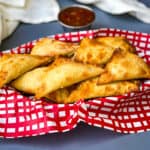 air fryer wontons in a basket with red wrapping