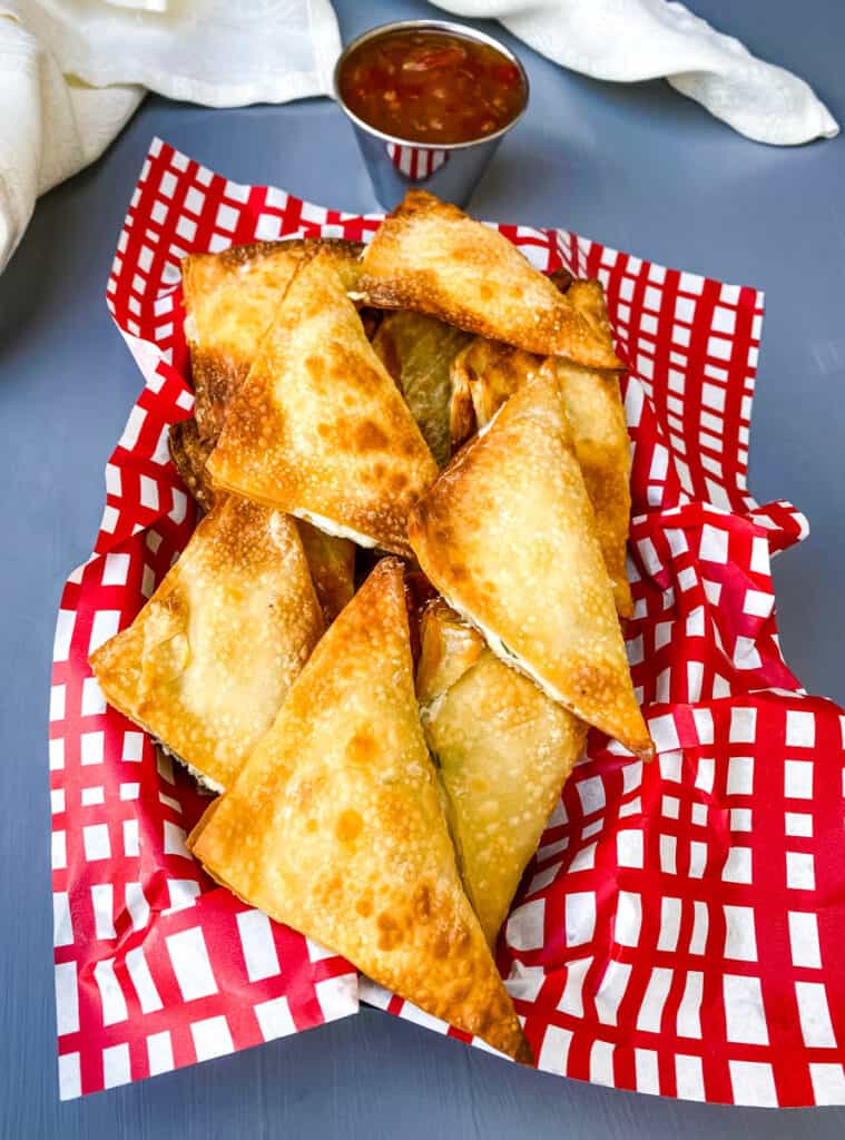 air fryer wontons in a basket with red wrapping