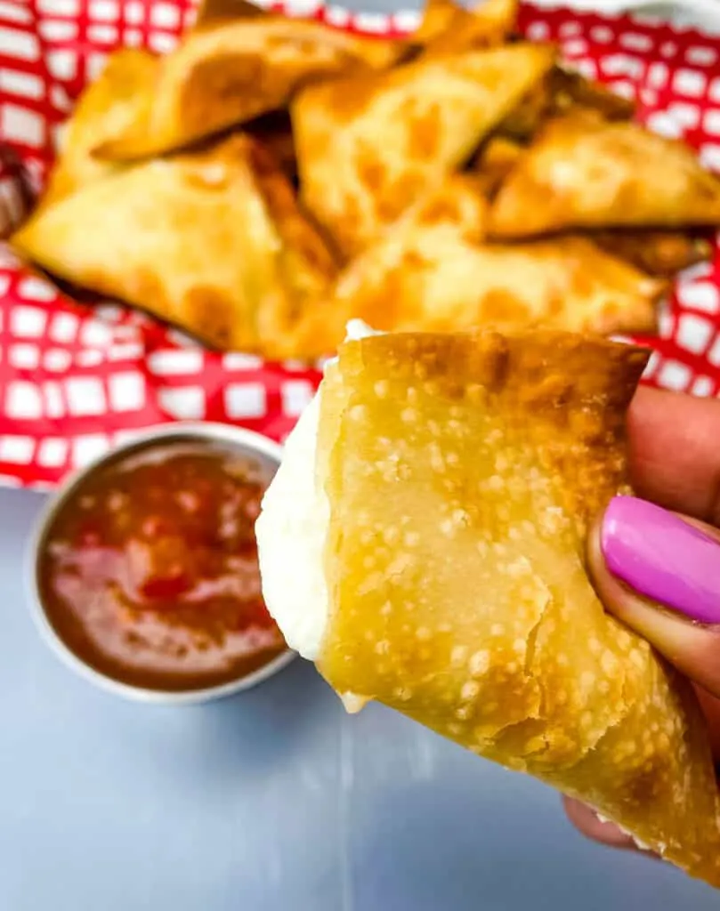 person holding air fryer wonton with cream cheese filling