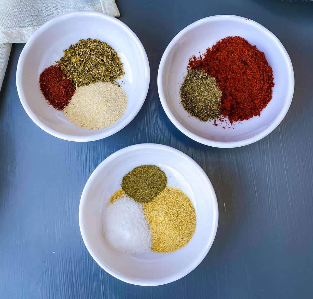 spices for blackened seasoning in 3 individual bowls