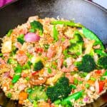 salmon fried rice with vegetables in a cast iron wok