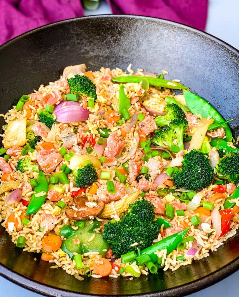 salmon fried rice with vegetables in a cast iron wok