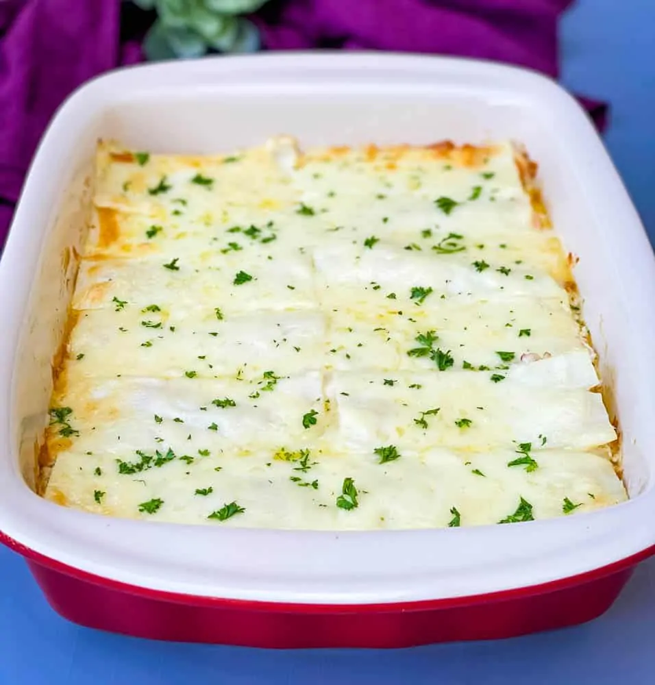 seafood lasagna in a red baking dish