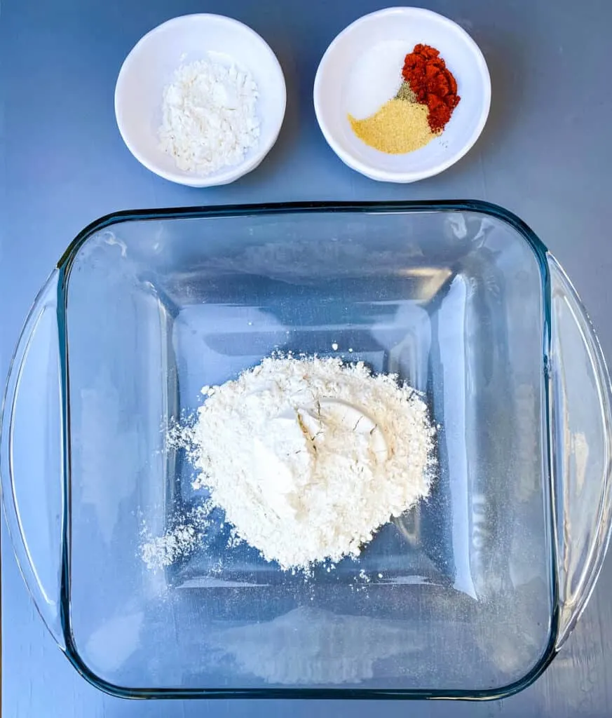 all purpose flour in a large glass dish with powdered sweetener and seasonings in separate bowls
