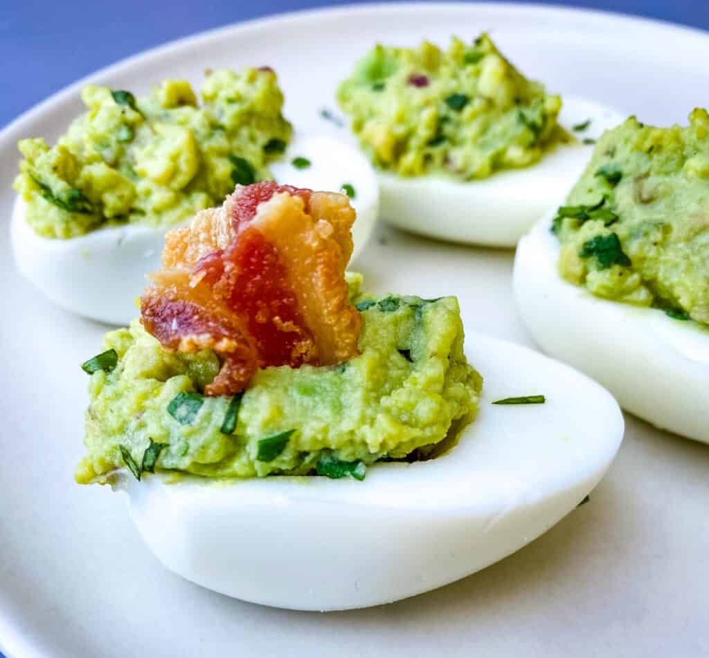 avocado deviled eggs with bacon on a